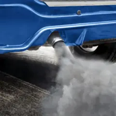 Dym z rury wydechowej niebieskiego samochodu. Zastanawiasz się, ile trwa wypalanie dpf na postoju?