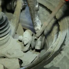 Mechanik bada przyczynę chrobotania przy skręcaniu kierownicą, sprawdzając zużyte elementy zawieszenia i przegub.