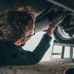 Mechanik bada podwozie auta, szukając przyczyn problemów z elektrozaworem skrzyni biegów. Objawy mogą być różne.