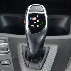 Bieg P, R, N, D, M/S na dźwigni skrzyni automatycznej BMW M. Oznaczenia biegów są czytelne.
