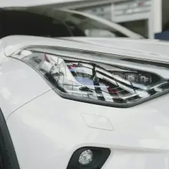 Biały samochód z nowoczesnymi reflektorami. Widać w nich szczegółowe diody w samochodzie, które nadają mu futurystyczny wygląd.