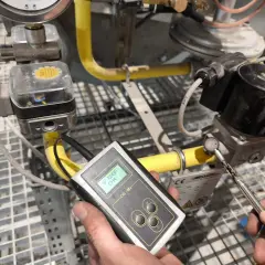 Technik przeprowadza sprawdzenie szczelności instalacji gazowej za pomocą detektora.