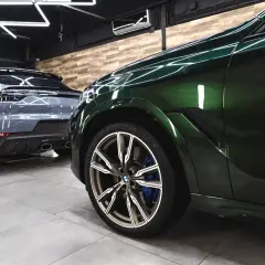 Zielony BMW i szary Porsche w garażu. To praca detailera, który dba o każdy detal.