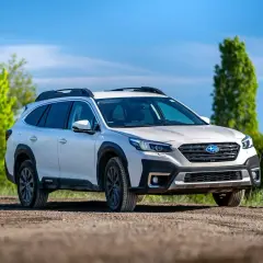 Biały Subaru Outback z napędem AWD na drodze gruntowej, gotowy na przygodę. Czy to lepsze niż 4WD?
