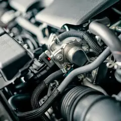 Zimny silnik diesla, widać falujące obroty. Skomplikowana budowa, przewody i elementy mechaniczne.