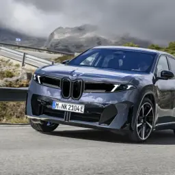 Szary, futurystyczny SUV na krętej drodze w górach. Czy to najlepszy samochód na świecie?