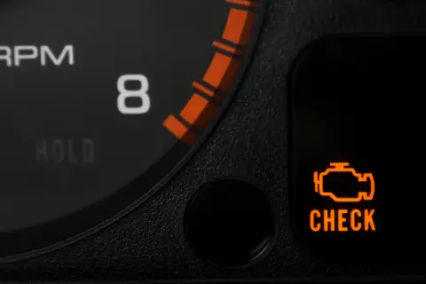 Pomarańczowa kontrolka "CHECK ENGINE" na desce rozdzielczej Hondy Civic. Znaczenie tej kontrolki może wskazywać na problem z silnikiem.