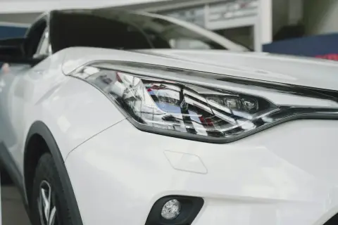 Biały samochód z nowoczesnymi reflektorami. Widać w nich szczegółowe diody w samochodzie, które nadają mu futurystyczny wygląd.