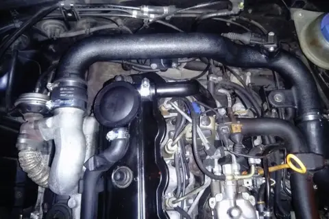 Silnik 1.9 TDI z widocznymi elementami układu dolotowego. Uszkodzona odma może powodować objawy takie jak dymienie i utrata mocy.