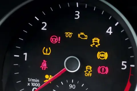 Deska rozdzielcza Peugeot 208 z zapalonymi kontrolkami: ABS, ESP, poduszki powietrzne, ciśnienie w oponach, hamulec ręczny.