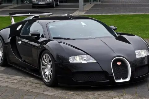 Czarny Bugatti Veyron, symbol luksusu i mocy, prezentuje się na tle innych drogich marek samochodów.