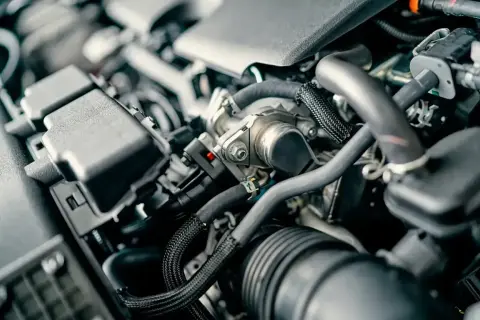 Zimny silnik diesla, widać falujące obroty. Skomplikowana budowa, przewody i elementy mechaniczne.
