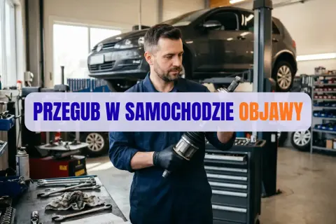 Mechanik w warsztacie samochodowym trzyma przegub napędowy.