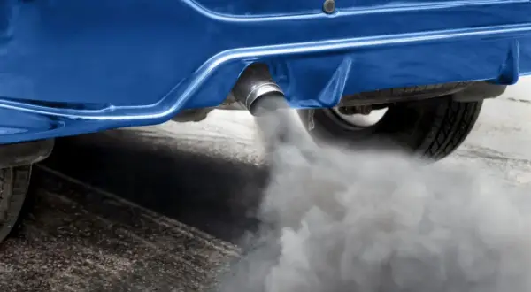 Dym z rury wydechowej niebieskiego samochodu. Zastanawiasz się, ile trwa wypalanie dpf na postoju?