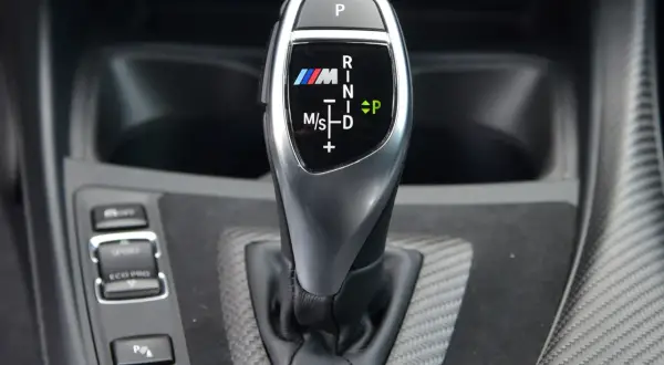 Bieg P, R, N, D, M/S na dźwigni skrzyni automatycznej BMW M. Oznaczenia biegów są czytelne.