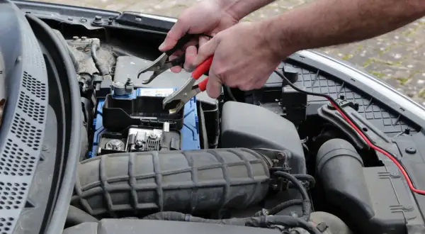 Podłączanie kabli rozruchowych do akumulatora. Gdy auto odpala i po chwili gaśnie diesel objawy mogą być różne, ale problem z prądem to częsta przyczyna.