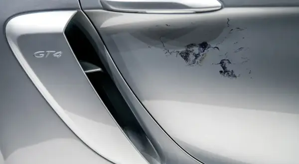 Uszkodzony lakier bezbarwny na srebrnym Porsche GT4. Jak usunąć lakier bezbarwny z samochodu, gdy jest tak zniszczony?