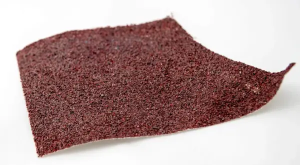 Fragment czerwonego papieru ściernego, idealnego do polerowania lakieru. Pytanie: jaki papier wodny do polerowania lakieru?