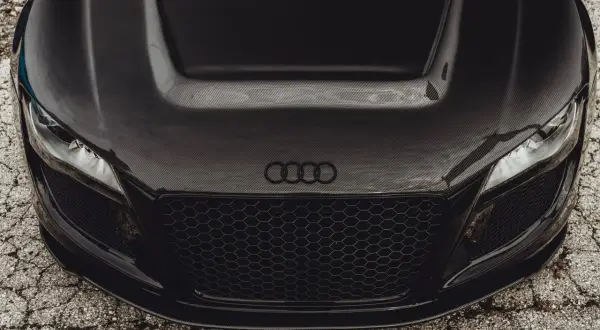 Maskownica i maska z włókna węglowego na czarnym aucie sportowym Audi.