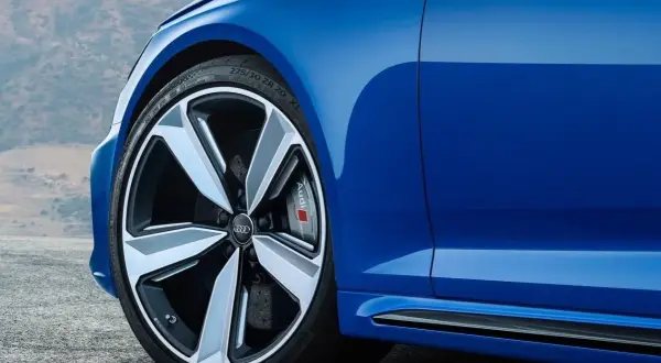 Niebieskie Audi z felgami. Czy głośność opony 71db to dużo? To cicha opona, która nie przeszkadza w podróży.