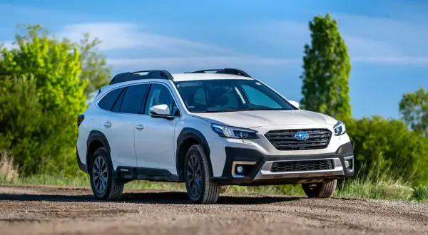 Biały Subaru Outback z napędem AWD na drodze gruntowej, gotowy na przygodę. Czy to lepsze niż 4WD?
