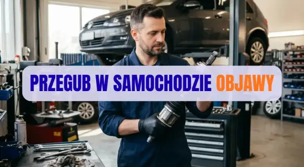 Mechanik w warsztacie samochodowym trzyma przegub napędowy.