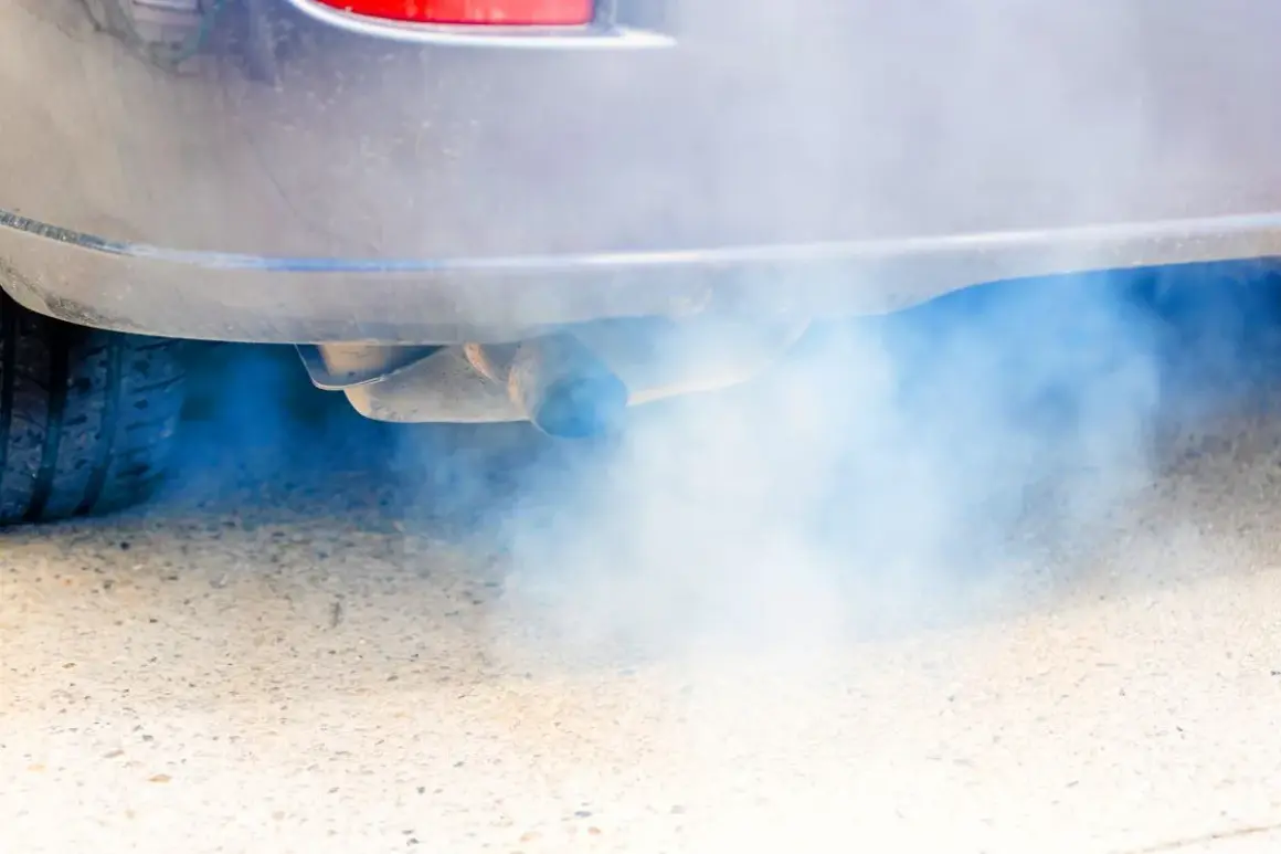 Niebieski dym z wydechu diesel, który wydobywa się z rury wydechowej samochodu, tworzy chmurę zanieczyszczeń.