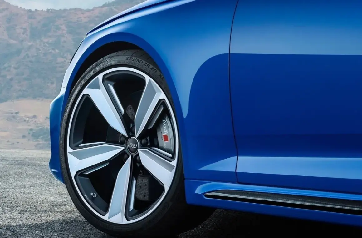 Niebieskie Audi z felgami. Czy głośność opony 71db to dużo? To cicha opona, która nie przeszkadza w podróży.