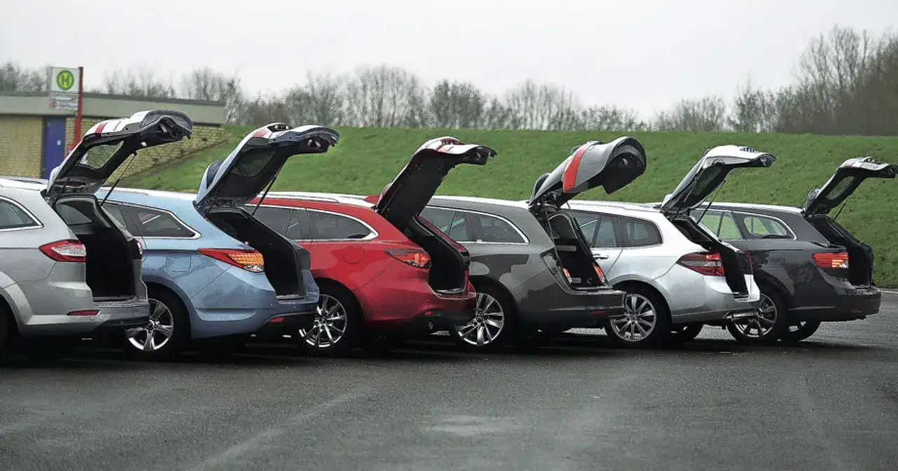 Rzędy samochodów: srebrny, niebieski, czerwony, szary i biały hatchback, wszystkie z otwartymi bagażnikami, gotowe do załadunku.