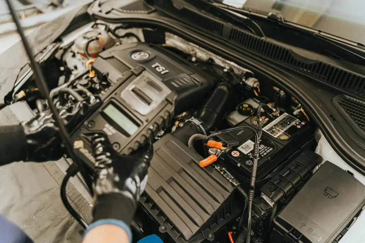 Mechanik diagnozuje czujnik położenia wału objawy za pomocą testera diagnostycznego podłączonego do silnika VW TSI.