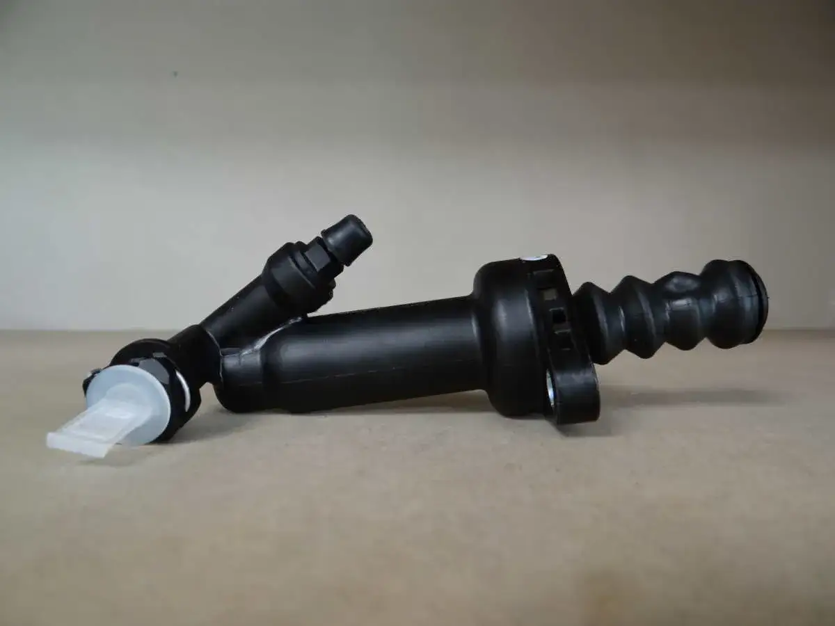 Część do regulacji sprzęgła hydraulicznego: czarny cylinder z gumową osłoną i białym elementem.