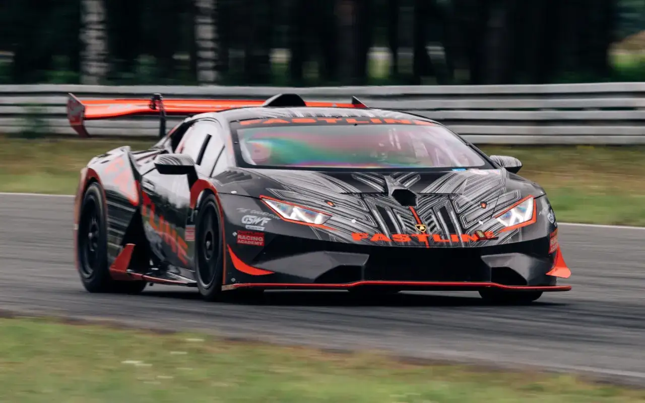 Czarny Lamborghini z pomarańczowymi akcentami na torze wyścigowym, gotowy na kurs jazdy ekstremalnej.
