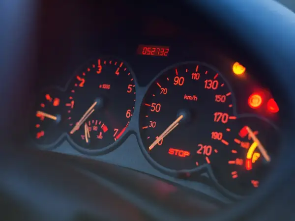 Deska rozdzielcza samochodu z podświetlanymi na czerwono wskaźnikami. Widoczny obrotomierz, prędkościomierz, wskaźnik paliwa i kontrolki. Czy to EPC?