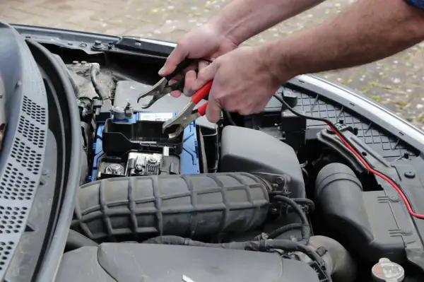 Podłączanie kabli rozruchowych do akumulatora. Gdy auto odpala i po chwili gaśnie diesel objawy mogą być różne, ale problem z prądem to częsta przyczyna.