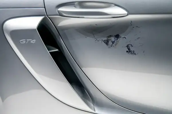 Uszkodzony lakier bezbarwny na srebrnym Porsche GT4. Jak usunąć lakier bezbarwny z samochodu, gdy jest tak zniszczony?