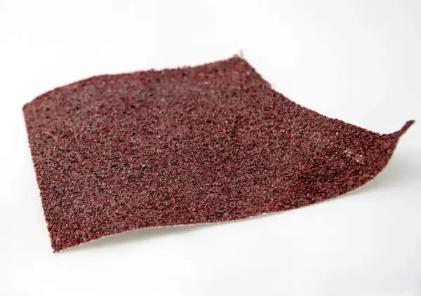 Fragment czerwonego papieru ściernego, idealnego do polerowania lakieru. Pytanie: jaki papier wodny do polerowania lakieru?