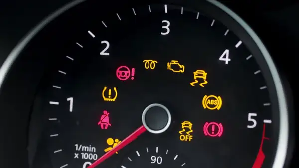 Deska rozdzielcza Peugeot 208 z zapalonymi kontrolkami: ABS, ESP, poduszki powietrzne, ciśnienie w oponach, hamulec ręczny.