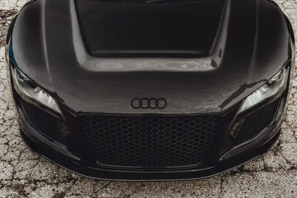 Maskownica i maska z włókna węglowego na czarnym aucie sportowym Audi.