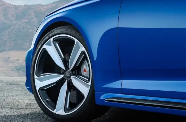 Niebieskie Audi z felgami. Czy głośność opony 71db to dużo? To cicha opona, która nie przeszkadza w podróży.