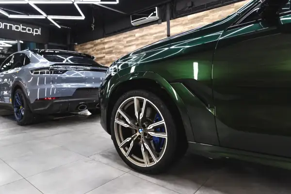 Zielony BMW i szary Porsche w garażu. To praca detailera, który dba o każdy detal.