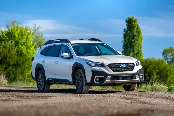 Biały Subaru Outback z napędem AWD na drodze gruntowej, gotowy na przygodę. Czy to lepsze niż 4WD?